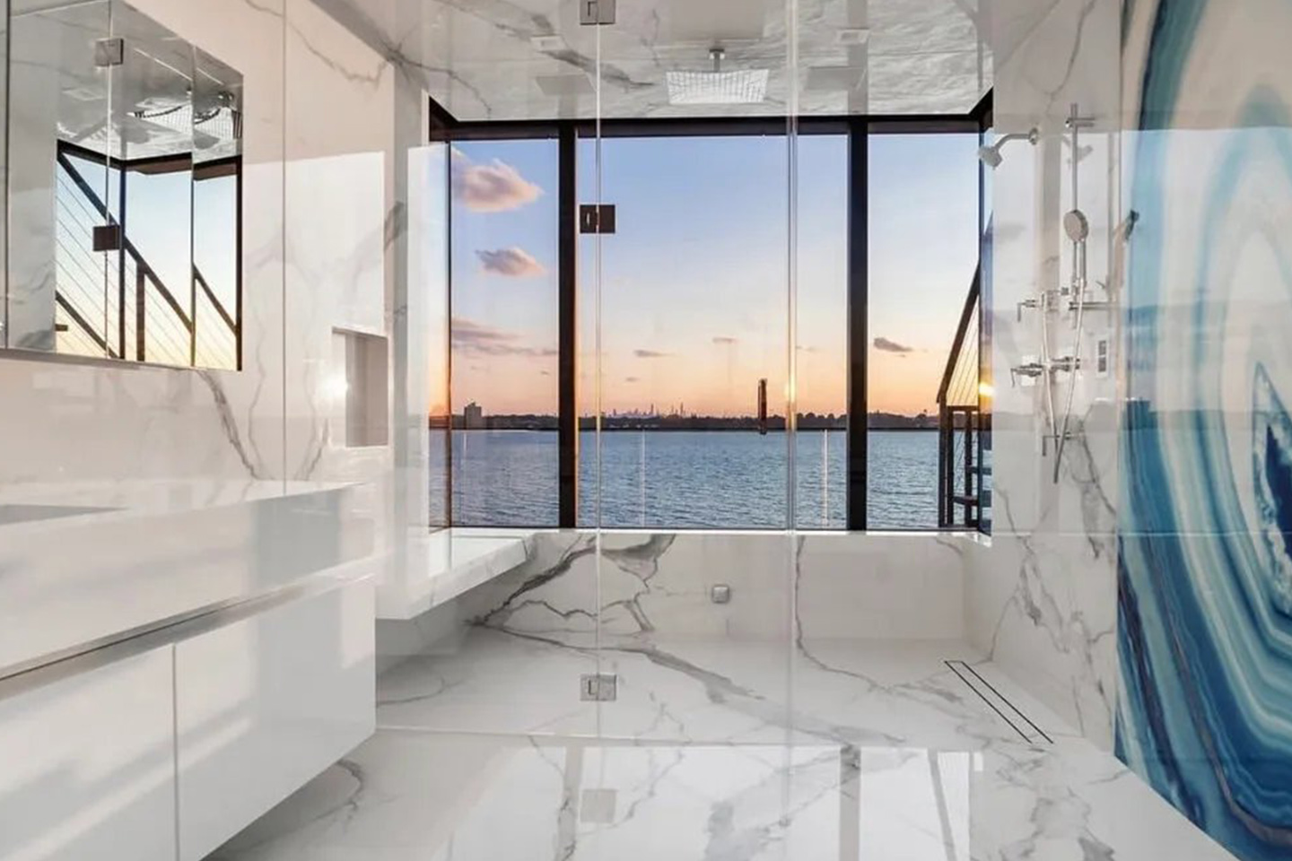 A bathroom with a large window and a view of the ocean.