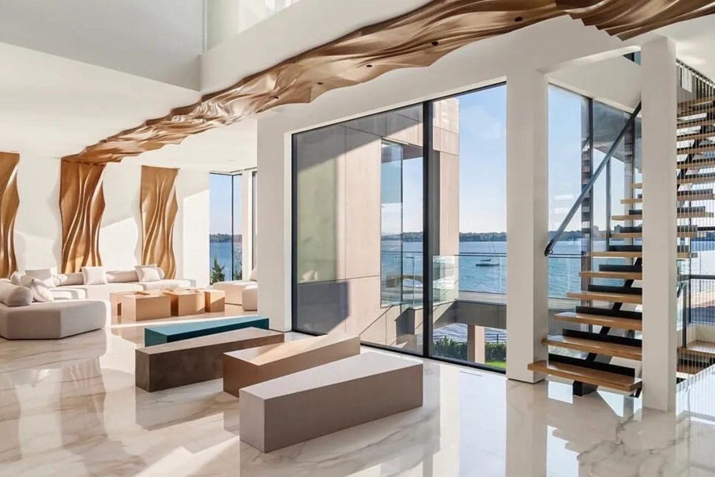 A living room with a large window and a view of the water.